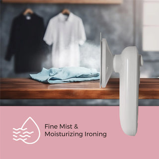 A Pursonic Portable Electric Travel Iron with quick heat-up releases a fine mist over a folded blue shirt on a wooden surface. In the background, two shirts are hanging; one black and one white. Below the image, an icon of water droplets reads "Fine Mist & Moisturizing Ironing.