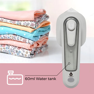 An image displaying a Portable Electric Travel Iron with a transparent 60ml water tank and rapid heat-up feature. The compact gray design includes a white nozzle. To the left, there is a stack of folded pastel-colored clothes. The brand name "Pursonic" is clearly visible.