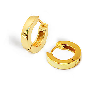 A pair of Essential Huggies by Sonia Hou Jewelry, lightweight and gold, is displayed on a white background. One earring stands upright, showcasing its full circular form, while the other lies flat, revealing the clasp used for fastening. These versatile earrings feature a smooth, shiny surface.