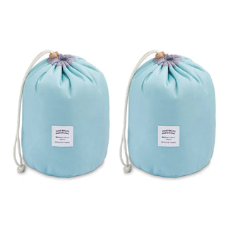 Two light blue drawstring bags with white cords and wooden toggles are placed side by side. Each bag has a white label that reads "WIND BLOWS RIVER FLOWS Amore Paris Waterproof Makeup Organizer Travel Bag." The background is plain white.