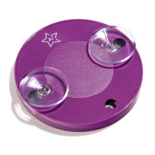 The Almost Famous 15X Vanity Mirror with Suction Lock (2-Pack) exhibits ultra-hold suction cups and a sleek, purple circular design. It has a slightly raised, textured center area and includes a small apple-shaped cut-out near the edge. Additionally, there is a white star featuring the text "AF 7" at the top for precision magnified reflection.